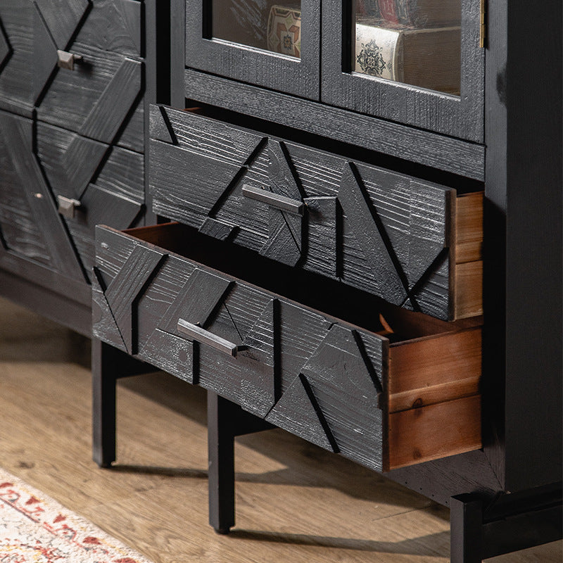 Close-up of the Arched Glass Door Display Cabinet with Geometric Accents by Furnishaus, featuring modern design and rich wood grain. Two slightly open drawers reveal intricate patterns, complemented by a red and beige patterned rug on the wooden floor completing the decor.